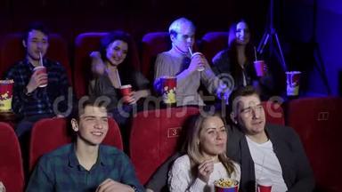 青少年坐在电影院看喜剧，吃<strong>爆米花</strong>，喝<strong>可乐</strong>